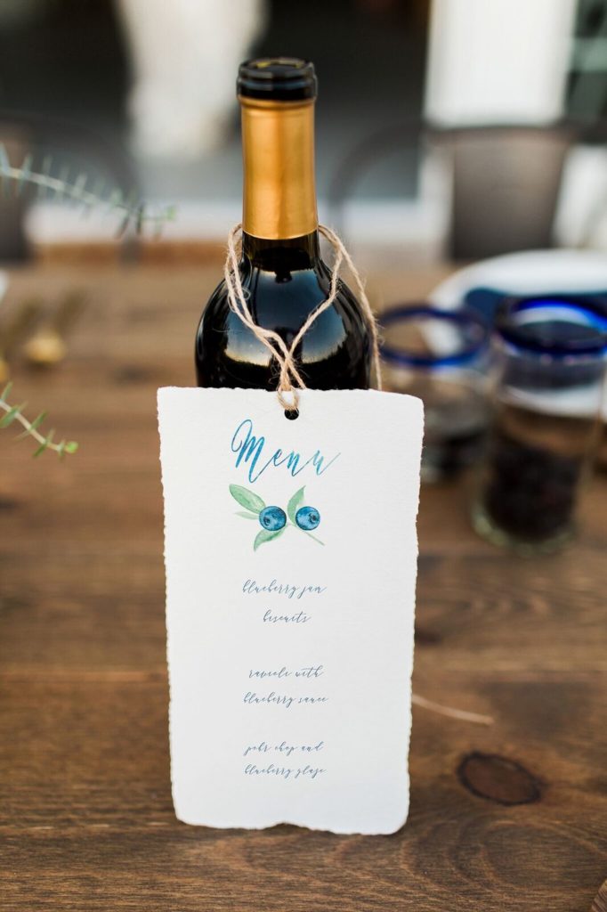 watercolored blueberry menu card hanging on wine bottle
