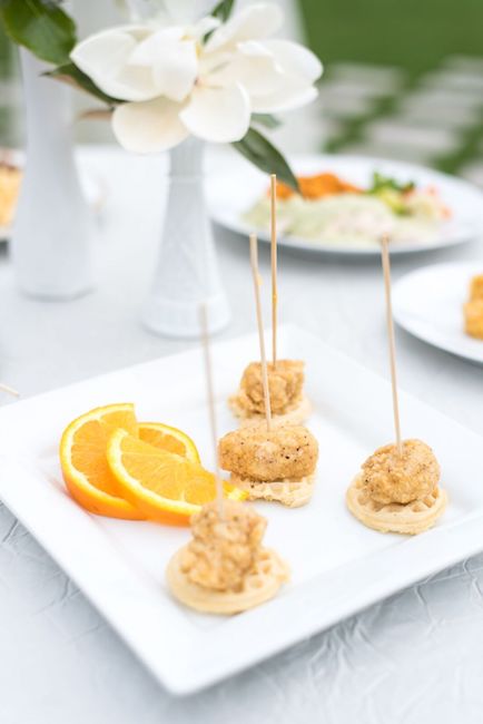 mini chicken and waffles on white square dish with sliced oranges