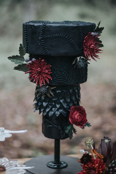 black upside down wedding cake with red sugar flowers 