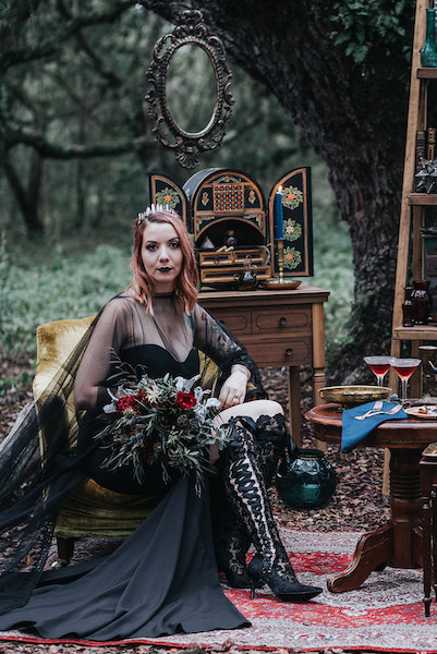 bride in black dress sitting on antique yellow chair