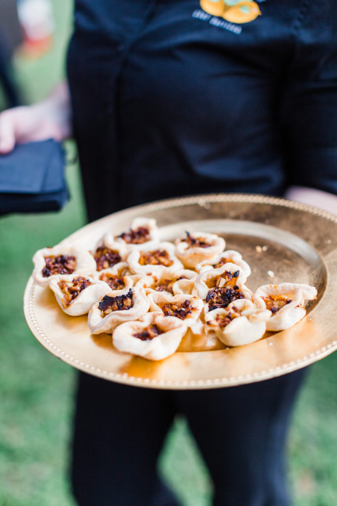 server holding a tray of appetizers at event 